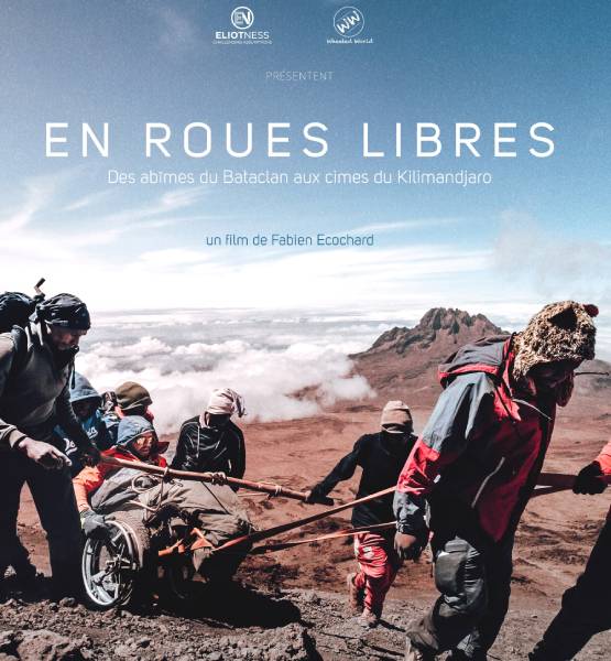 l'affiche du film "En Roues libres" avec des personnes qui tirent une personne en fauteuil roulant à la montagne