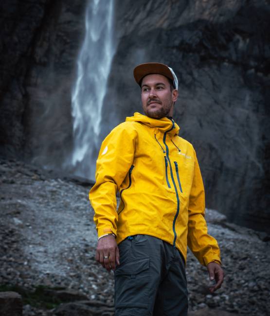 un jeune homme face à une cascade