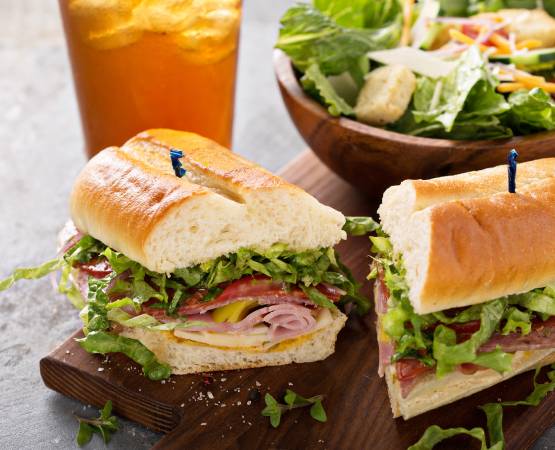 un sandwich coupé en deux avec un ice tea