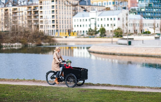 Une dame à vélo se promenant près d'une rivière. 