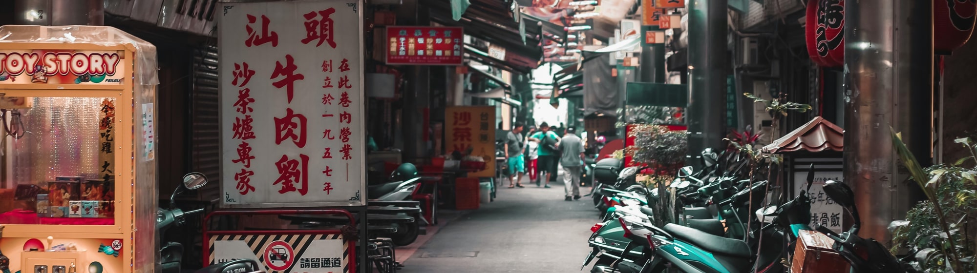 Rue dans le centre ville de Taiwan avec des motos garées sur le cote. 